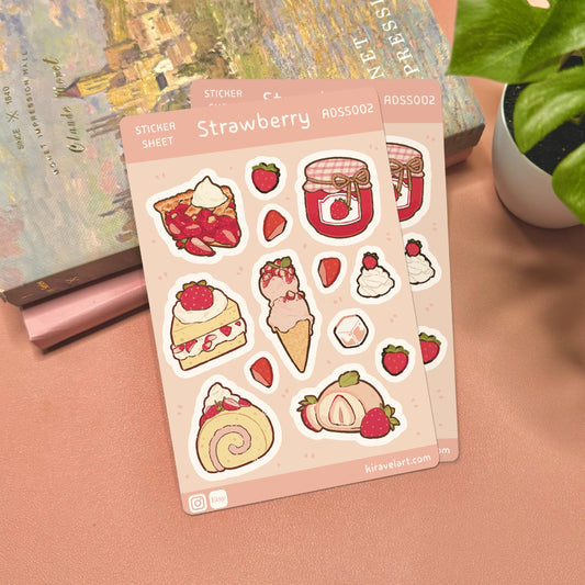 Sheet of strawberry-themed stickers on a pink surface with a plant and book in the background.